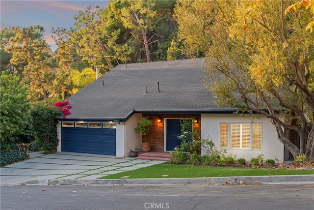 9767 Blantyre Dr, Beverly Hills, CA 90210 - view of front of home with an attached garage, driveway, stucco siding, and a front lawn