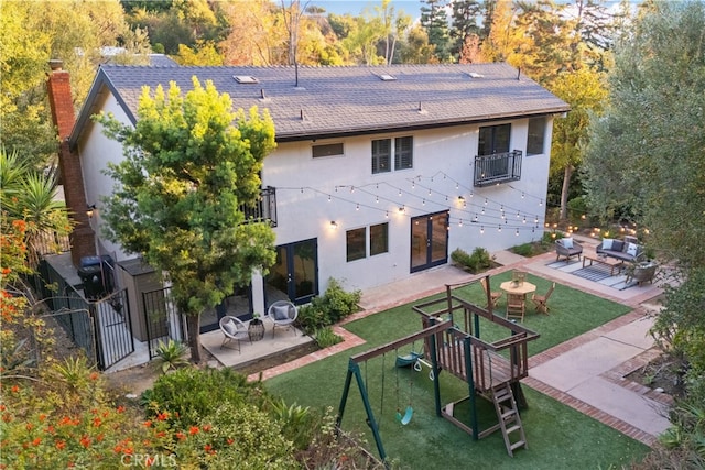 9767 Blantyre Dr, Beverly Hills, CA 90210 - rear view of property with stucco siding, a playground, a balcony, and a patio area