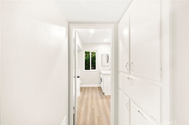 28610 Portsmouth Dr, Menifee, CA 92586 - corridor featuring light wood-type flooring and a sink