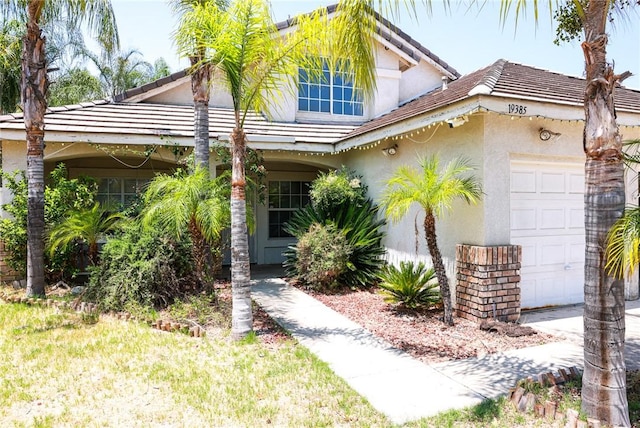 19385 Live Oak Ln, Lake Elsinore, CA 92530 - view of front of house featuring a garage, stucco siding, and a tiled roof