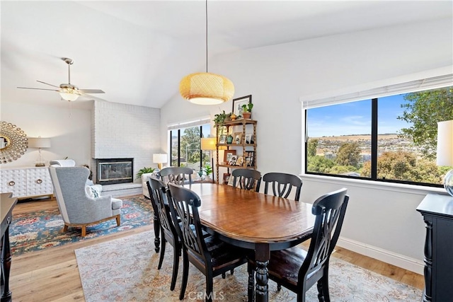 952 Margarita Ave, Grover Beach, CA 93433 - dining room featuring light wood-style flooring, a brick fireplace, vaulted ceiling, and a ceiling fan