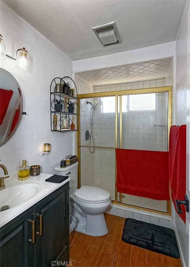 13665 Hidden Valley Rd, Victorville, CA 92395 - full bath featuring wood finished floors, vanity, a shower stall, and a textured ceiling