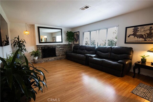 9025 La Vine St, Rancho Cucamonga, CA 91701 - living area featuring wood finished floors and a stone fireplace