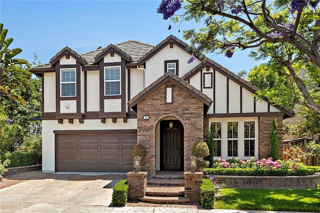 14 Downing St, Ladera Ranch, CA 92694 - tudor house featuring driveway, stucco siding, an attached garage, a tiled roof, and brick siding