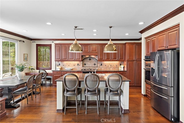 14 Downing St, Ladera Ranch, CA 92694 - kitchen featuring stainless steel appliances, crown molding, a kitchen breakfast bar, a center island with sink, and backsplash