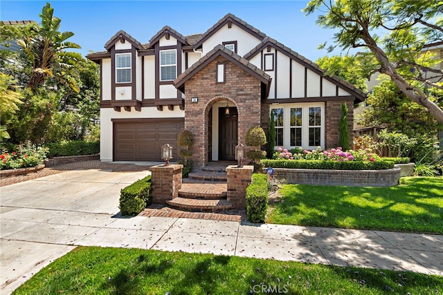 14 Downing St, Ladera Ranch, CA 92694 - tudor-style house with driveway, stucco siding, an attached garage, a front yard, and brick siding