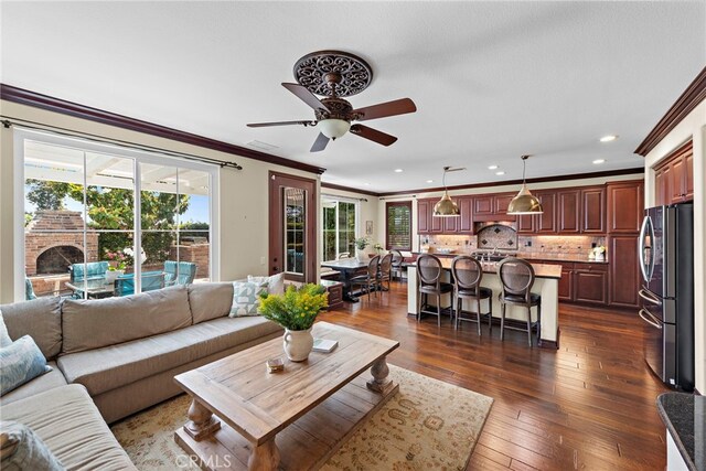 14 Downing St, Ladera Ranch, CA 92694 - living area with healthy amount of natural light, ornamental molding, a ceiling fan, dark wood-type flooring, and recessed lighting