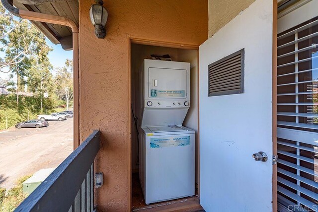 17159 W Bernardo Dr Unit 202, San Diego, CA 92127 - laundry area featuring stacked washer / dryer and a textured wall