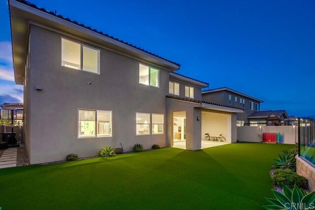 1873 El Paseo Ave, Chula Vista, CA 91913 - back of house at night with stucco siding, a tiled roof, and a patio area