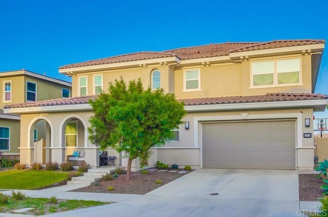 1873 El Paseo Ave, Chula Vista, CA 91913 - mediterranean / spanish-style house with a tiled roof, an attached garage, driveway, stucco siding, and a porch