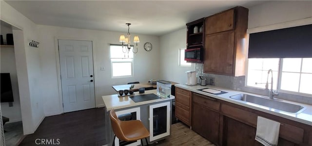 12101 Kern Ave, Boron, CA 93516 - kitchen with dark wood-style flooring, light countertops, a chandelier, and decorative backsplash
