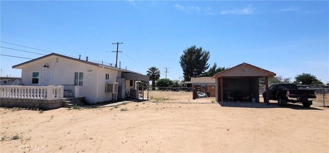 12101 Kern Ave, Boron, CA 93516 - view of yard with dirt driveway, a detached carport, and a wooden deck