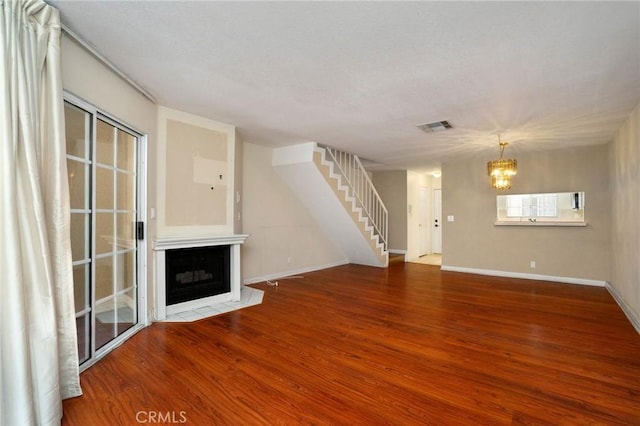 333 W Alameda Ave Unit 208, Burbank, CA 91506 - unfurnished living room featuring a chandelier, wood finished floors, stairs, and a fireplace with flush hearth