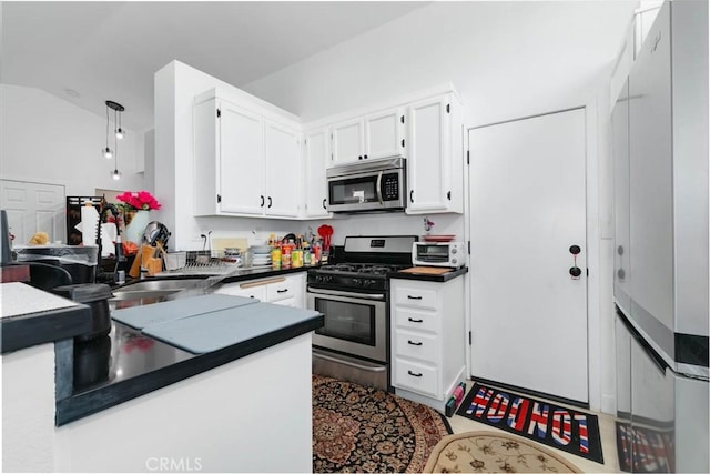 13035 Troy Ct, Victorville, CA 92395 - kitchen with stainless steel appliances, dark countertops, white cabinetry, and lofted ceiling