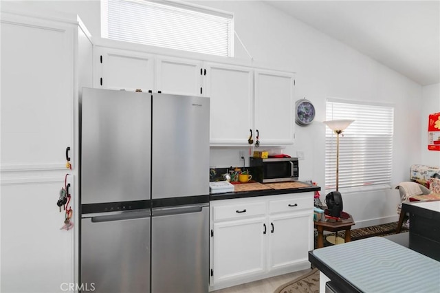 13035 Troy Ct, Victorville, CA 92395 - kitchen featuring appliances with stainless steel finishes, lofted ceiling, white cabinets, and dark countertops