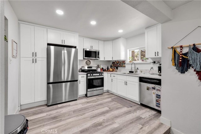 56565 Antelope Trl, Yucca Valley, CA 92284 - kitchen with stainless steel appliances, white cabinets, light wood-style floors, light countertops, and recessed lighting