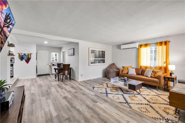 56565 Antelope Trl, Yucca Valley, CA 92284 - living area with a wall mounted AC, a textured ceiling, light wood finished floors, and recessed lighting