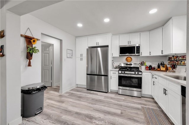 56565 Antelope Trl, Yucca Valley, CA 92284 - kitchen featuring stainless steel appliances, light countertops, light wood-style floors, white cabinets, and recessed lighting
