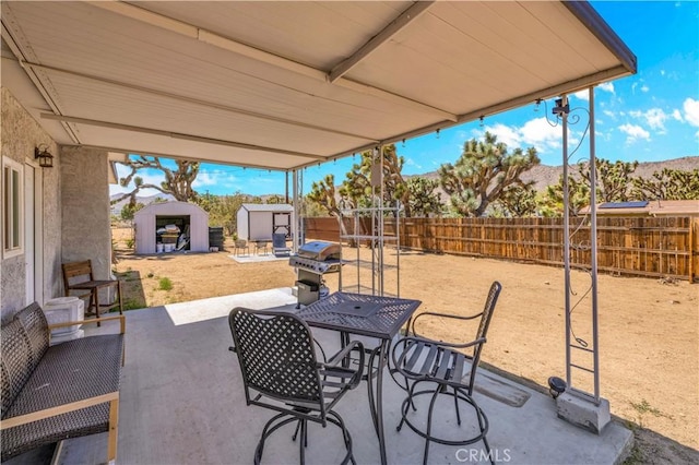 56565 Antelope Trl, Yucca Valley, CA 92284 - fenced backyard with a storage unit, a patio area, outdoor dining space, and area for grilling