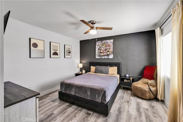 56565 Antelope Trl, Yucca Valley, CA 92284 - bedroom with wood finished floors, ceiling fan, and an accent wall