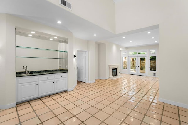3647 Paseo Vista Famosa, Rancho Santa Fe, CA 92091 - unfurnished living room featuring recessed lighting, french doors, light tile patterned floors, bar with sink, and a high end fireplace