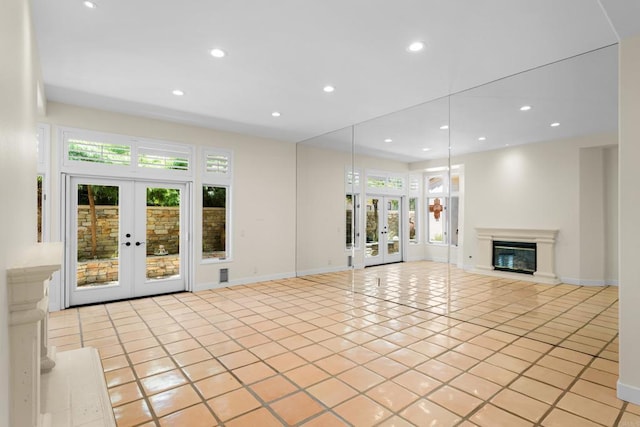 3647 Paseo Vista Famosa, Rancho Santa Fe, CA 92091 - unfurnished living room featuring french doors, healthy amount of natural light, recessed lighting, light tile patterned floors, and a glass covered fireplace