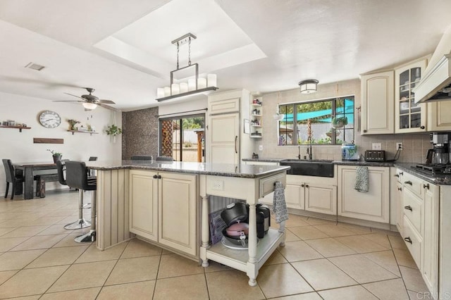 26267 Bellemore Dr, Ramona, CA 92065 - kitchen featuring cream cabinets, open shelves, a center island, backsplash, and ceiling fan