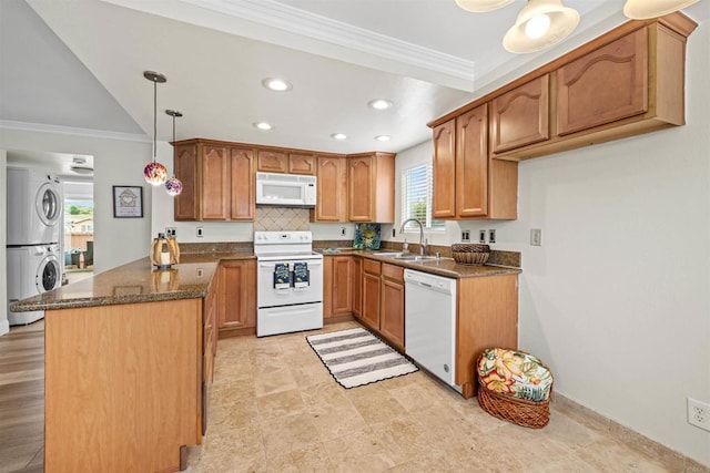 31916 Del Cielo Este Unit 38, Bonsall, CA 92003 - kitchen with white appliances, stacked washer / drying machine, a peninsula, ornamental molding, and dark stone countertops