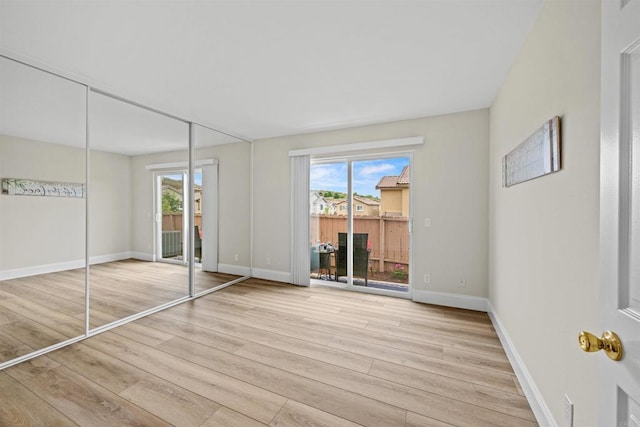 31916 Del Cielo Este Unit 38, Bonsall, CA 92003 - unfurnished bedroom featuring access to outside, light wood-style flooring, and multiple windows