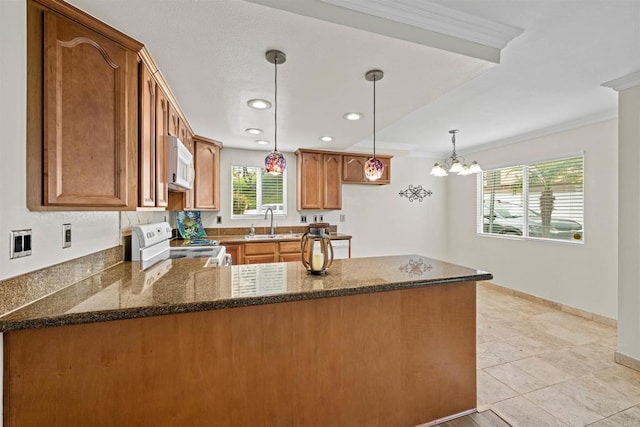 31916 Del Cielo Este Unit 38, Bonsall, CA 92003 - kitchen featuring white appliances, a peninsula, ornamental molding, dark stone counters, and brown cabinets