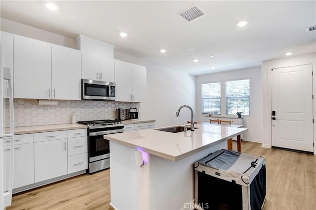 3934 Lavine Way Unit 108, Corona, CA 92883 - kitchen featuring stainless steel appliances, light wood-style flooring, tasteful backsplash, recessed lighting, and light countertops