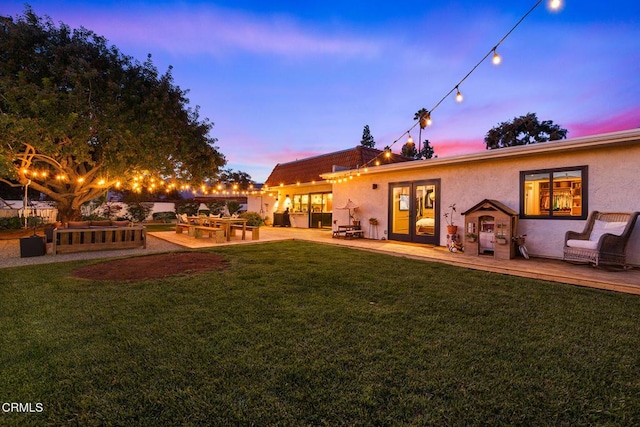 705 Alomar St, Ojai, CA 93023 - back of house at dusk featuring stucco siding, a lawn, and a patio area