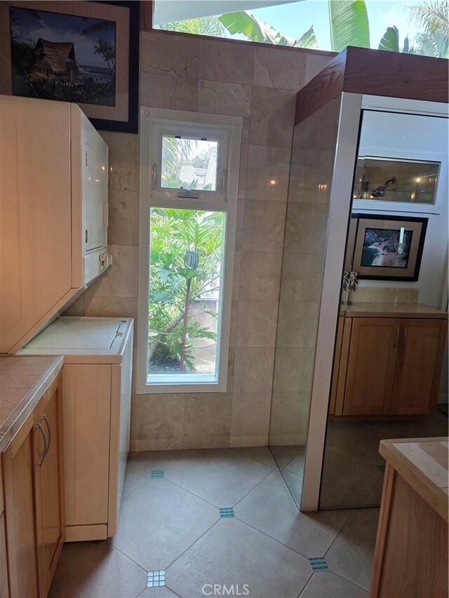 2774 Sawtelle Blvd, Los Angeles, CA 90064 - washroom featuring light tile patterned floors, washer / dryer, and tile walls