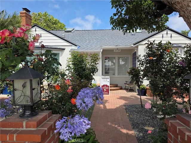 2774 Sawtelle Blvd, Los Angeles, CA 90064 - view of front of property with roof with shingles, stucco siding, and a chimney