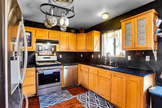 5982 Morongo Rd Unit 29, Palms, CA 92277 - kitchen featuring stainless steel appliances, under cabinet range hood, dark wood-style floors, dark countertops, and glass insert cabinets
