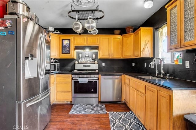 5982 Morongo Rd Unit 29, Palms, CA 92277 - kitchen featuring appliances with stainless steel finishes, dark countertops, dark wood finished floors, and glass insert cabinets