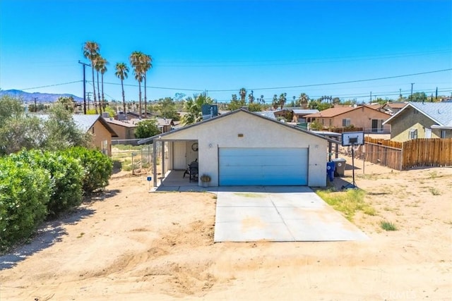 5982 Morongo Rd Unit 29, Palms, CA 92277 - view of front facade featuring a garage, a residential view, driveway, and stucco siding