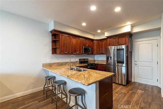 7019 Passons Blvd, Pico Rivera, CA 90660 - kitchen featuring appliances with stainless steel finishes, a peninsula, dark wood-style flooring, a breakfast bar area, and open shelves