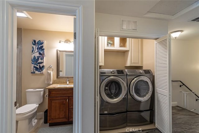 7019 Passons Blvd, Pico Rivera, CA 90660 - laundry room featuring cabinet space, washer and clothes dryer, and wood finished floors