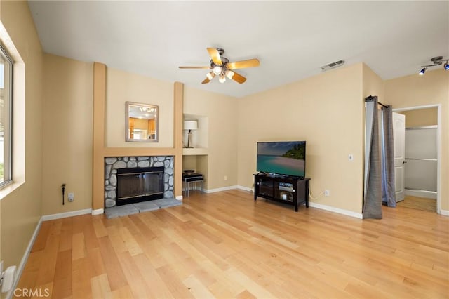 33087 Corte Ganso, Temecula, CA 92592 - living room featuring ceiling fan, light wood-style flooring, and a stone fireplace