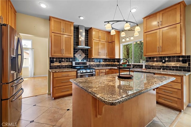 33087 Corte Ganso, Temecula, CA 92592 - kitchen with stainless steel appliances, wall chimney range hood, dark stone counters, backsplash, and a center island
