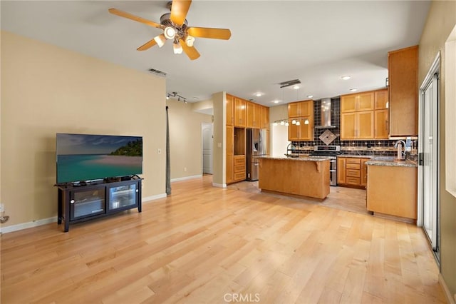 33087 Corte Ganso, Temecula, CA 92592 - kitchen with stainless steel appliances, wall chimney exhaust hood, a center island, light wood finished floors, and tasteful backsplash