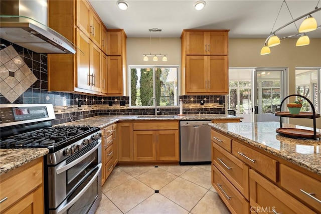 33087 Corte Ganso, Temecula, CA 92592 - kitchen with stainless steel appliances, wall chimney exhaust hood, tasteful backsplash, light tile patterned flooring, and pendant lighting