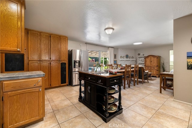 7 Calgary Ln, Chico, CA 95926 - kitchen featuring stainless steel fridge with ice dispenser, light tile patterned floors, tile countertops, and brown cabinets