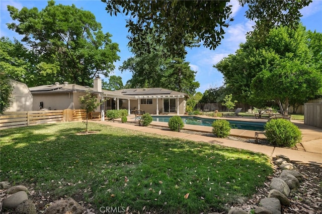 7 Calgary Ln, Chico, CA 95926 - back of house with roof mounted solar panels, a fenced backyard, and a patio