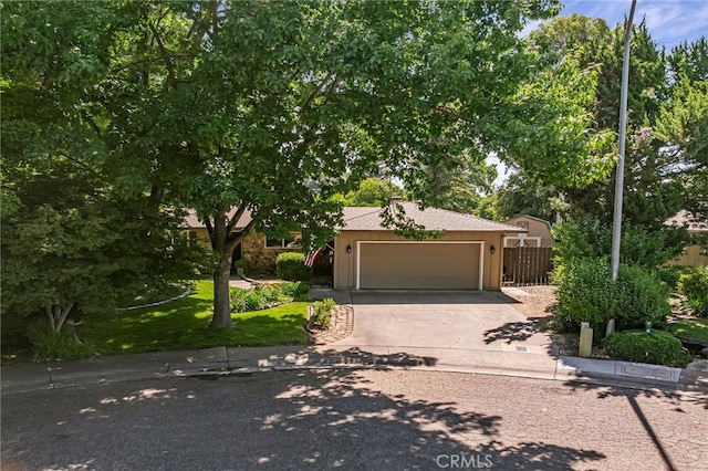 7 Calgary Ln, Chico, CA 95926 - view of property hidden behind natural elements featuring concrete driveway and a garage