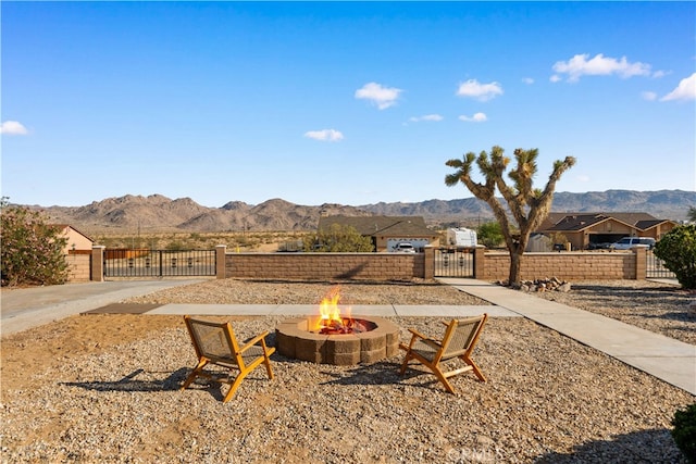 62290 Crestview Dr, Joshua Tree, CA 92252 - view of patio / terrace with a gate, a mountain view, an outdoor fire pit, and a fenced front yard