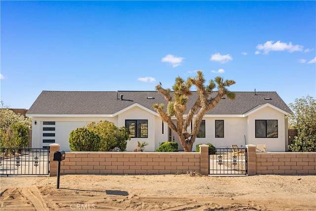 62290 Crestview Dr, Joshua Tree, CA 92252 - view of front of property featuring a fenced front yard, a gate, stucco siding, and a garage