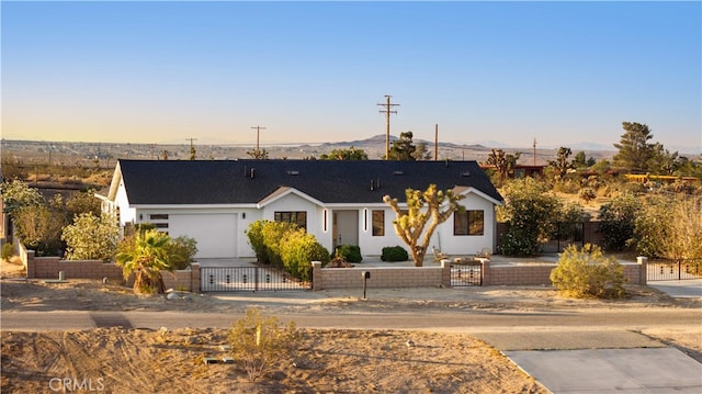 62290 Crestview Dr, Joshua Tree, CA 92252 - single story home featuring a fenced front yard, an attached garage, a mountain view, and stucco siding