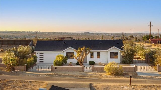 62290 Crestview Dr, Joshua Tree, CA 92252 - view of front of property with a fenced front yard, a gate, an attached garage, stucco siding, and a mountain view